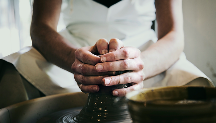 Person blending clay on wheel
