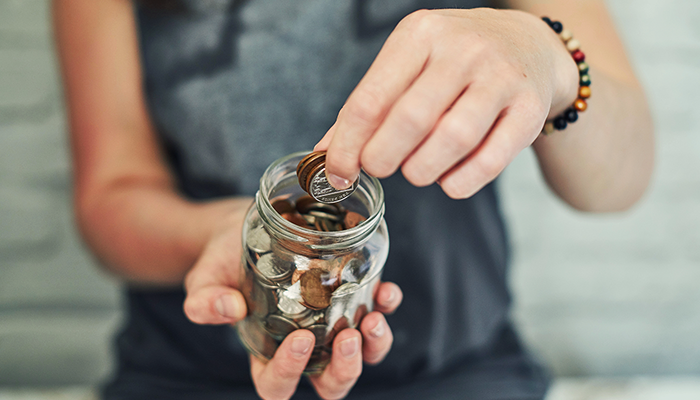 Woman taking coins from a jar